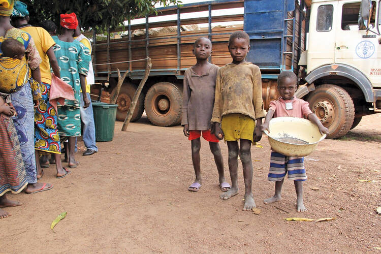 SEEDS OF HOPE. Children at a small village on the outskirts of Bossangoa wait with their parents for a distribution of seeds and cultivation tools from Catholic Relief Services.