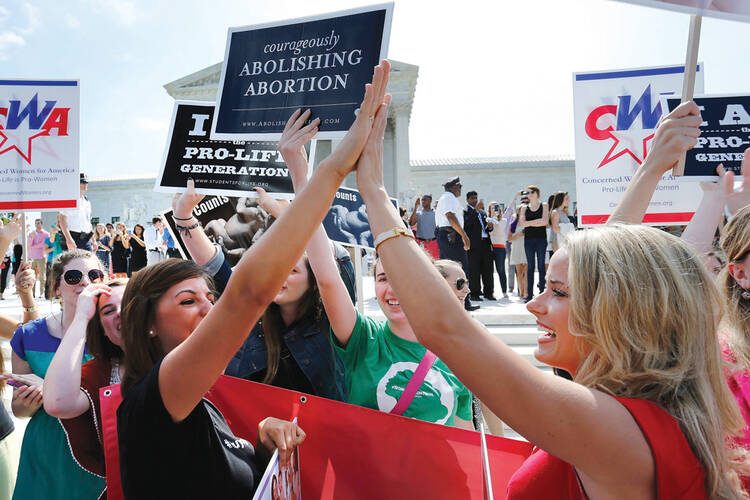 HIGH FIVE TO FOUR. Pro-life demonstrators on June 30 outside the U.S. Supreme Court in Washington.