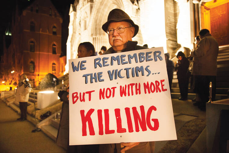 ￼LETHAL DECISION. Deacon John Flanigan protests outside St. Louis University College Church on Jan. 28.