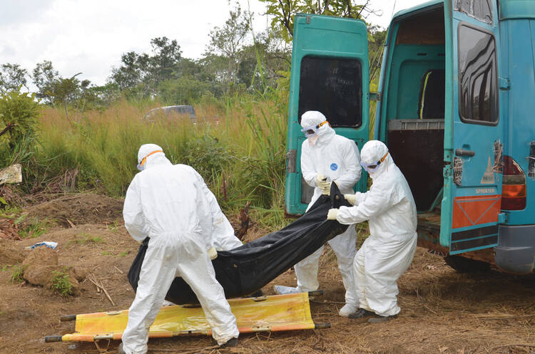 WORK OF MERCY. Health workers at a burial in northern Sierra Leone. 