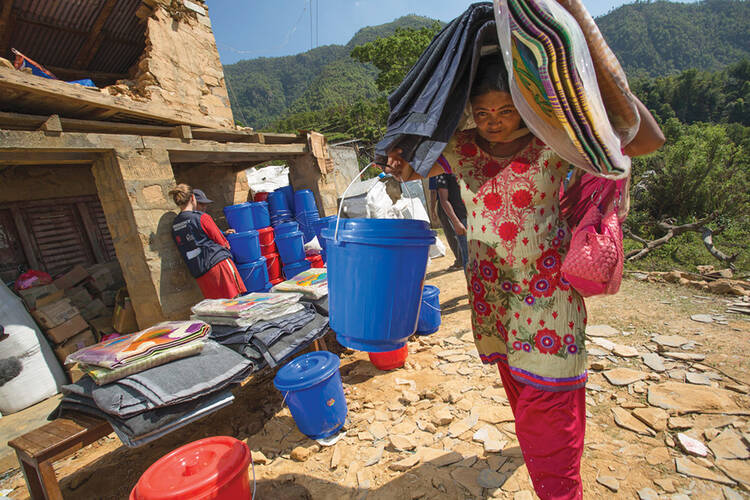 CONTAINING A CRISIS. Catholic Relief Services’ staff distribute shelter and hygiene kits in a village in Nepal’s Gorkha District.