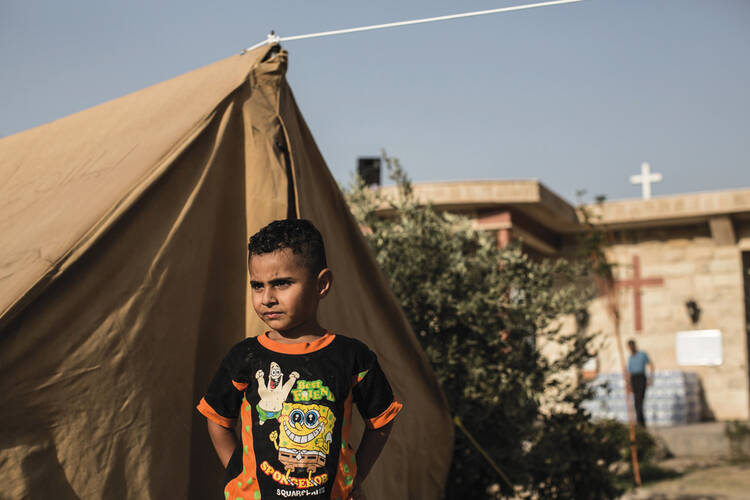 CHRISTIAN EXODUS. A boy and his family take refuge near St. Eliyah Church in Erbil on Aug. 26. 