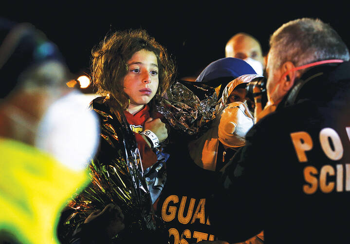 ￼A YOUNG SURVIVOR. Italian police photograph a child after migrants arrived by boat at the Sicilian harbor of Pozzallo on April 19, 2015.