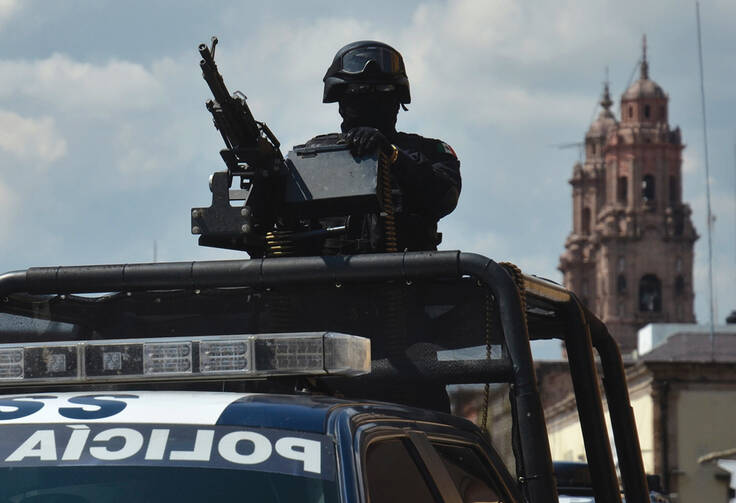 State of Siege: A federal police officer ready for action atop a vehicle in the Mexican state of Michoacan on Oct. 28