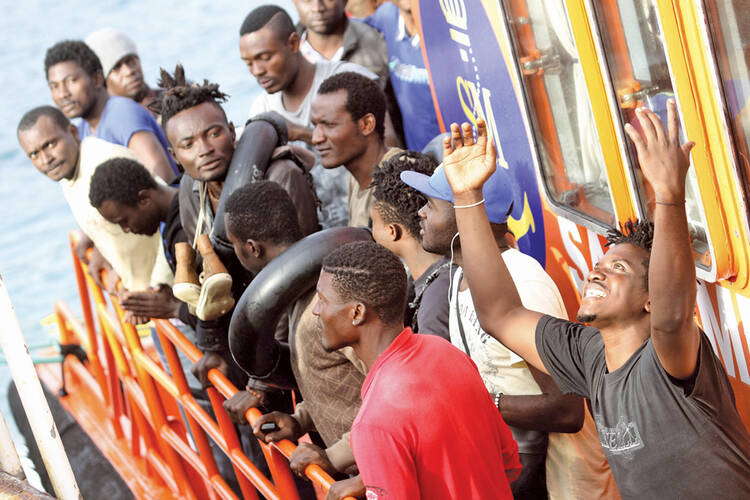 LOST AT SEA. Sub-Saharan migrants greet a Spanish rescue boat at Tarifa, Spain.