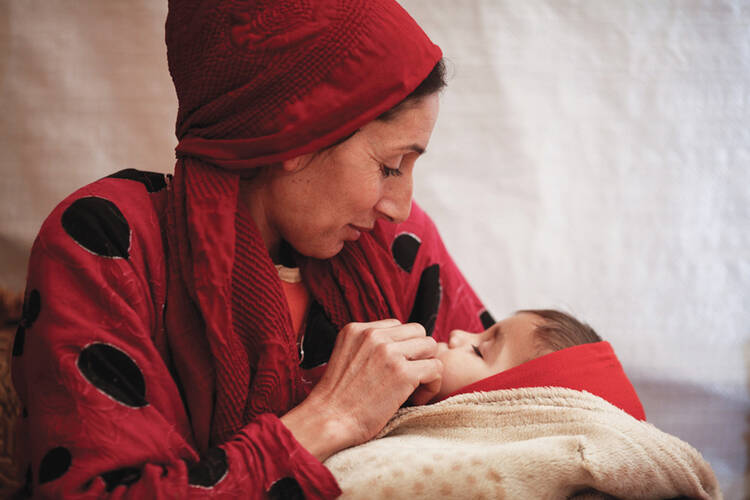 MOTHER AND CHILD. Souad Mohamed, a Syrian refugee, with her her baby inside a tent in Lebanon’s Bekaa Valley, December 2013.