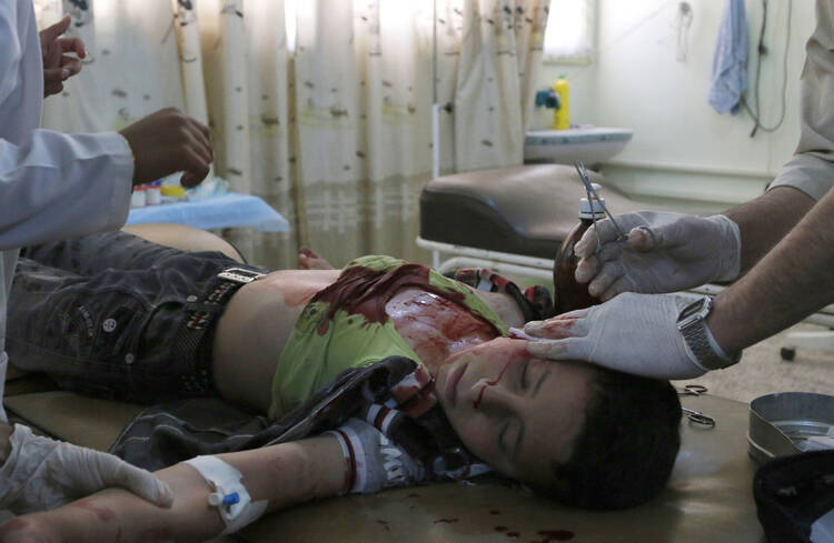 A medic treats a boy who was injured after what activists said was an airstrike by forces loyal to Syrian President Bashar Assad at a hospital in Idlib, Syria, on May 15. 