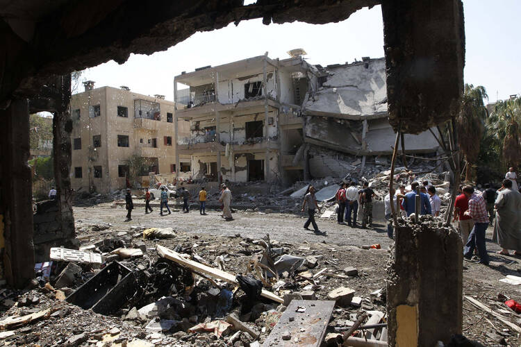 People inspect the damage at a site hit by what activists say was a car bomb in Raqqa, Syria, Aug. 29. (CNS photo/Nour Fourat, Reuters)