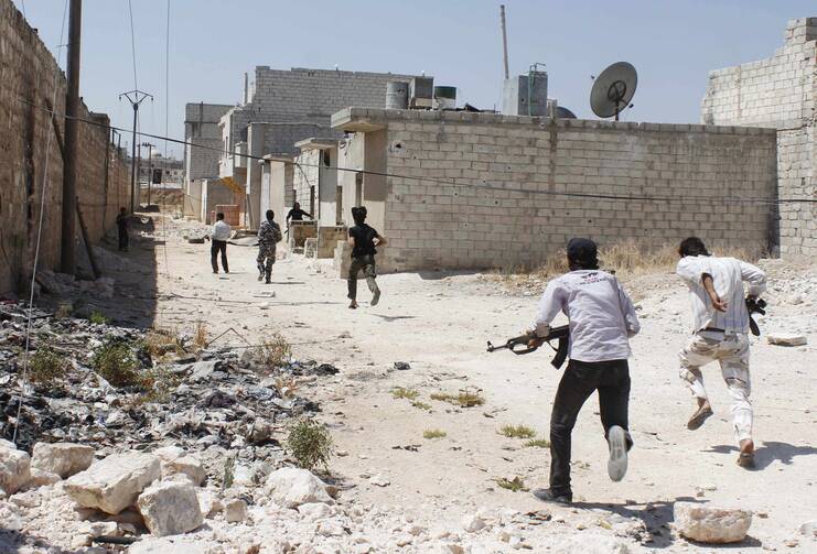 Free Syrian Army fighters run to take cover from snipers loyal to President Bashar Assad near Aleppo International airport in Syria Aug. 28. (CNS photo/Molhem Barakat, Reuters)