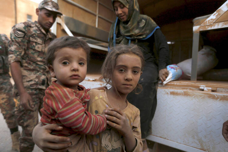 Syrian refugee children covered with dust arrive Sept. 10 at the Jordanian border with Syria and Iraq, near the town of Ruwaished, which is close to Amman, Jordan. (CNS photo/Muhammad Hamed, Reuters)