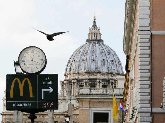 A sign in front of St. Peter's Basilica points to the newest McDonald's restaurant in Rome, next to the Vatican. Jan. 3, 2017. Photo courtesy of Reuters/Alessandro Bianchi