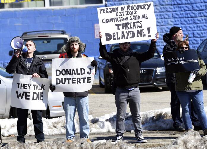 Protesters gather near the Manchester Central Fire Station in Manchester, N.H., Monday, March 19, 2018, where President Donald Trump madee an unscheduled visit. Trump is in New Hampshire to unveil more of his plan to combat the nation's opioid crisis. (AP Photo/Susan Walsh)