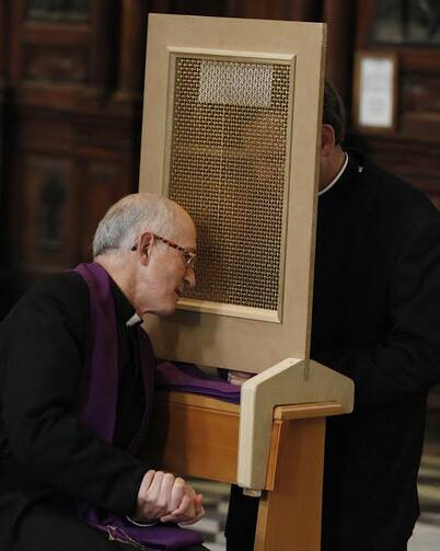 Priest of the Legionaries of Christ hears confession during ordination of 31 new Legionary priests. (CNS photo/Paul Haring)