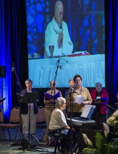 Projected on a screen above choir Archbishop Carlo Maria Vigano, apostolic nuncio to the United States, celebrates Mass during a 2013 Leadership Conference of Women Religious assembly in Kissimmee, Fla. (CNS photo/Roberto Gonzalez)