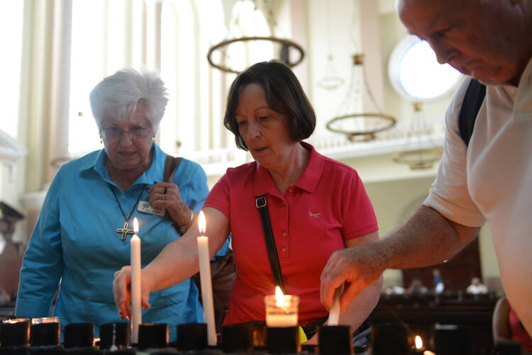 U.S. pilgrims light candles in the cathedral in San Salvador May 21, two days before the beatification of Archbishop Oscar Romero. (CNS photo/Lissette Lemus)
