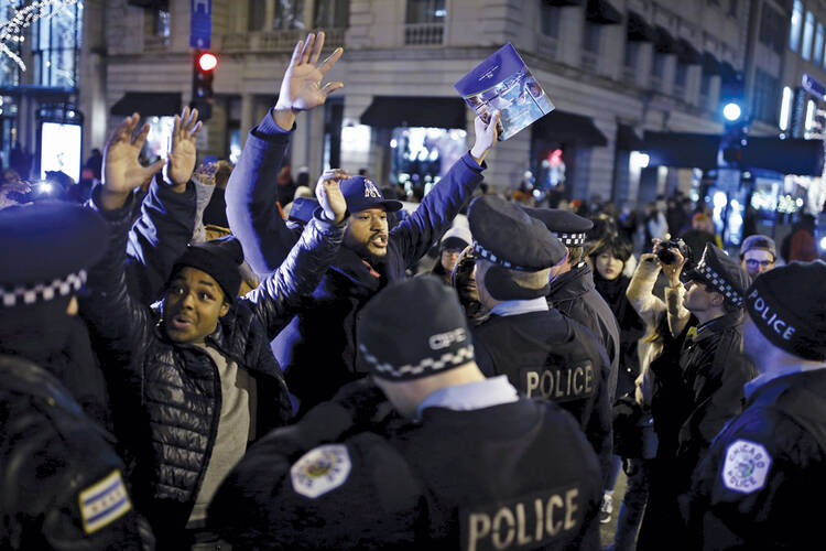 HANDS UP. Demonstrators confront police officers during a protest in reaction to the fatal shooting of Laquan McDonald in Chicago, Ill., on Nov. 27, 2015. 