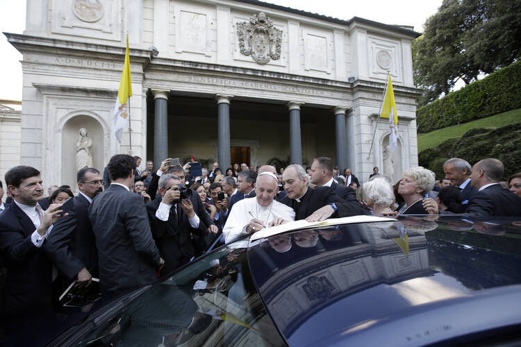 Pope Francis, with Monsignor Marcelo Sanchez Sorondo at right, signs a declaration during a two-day Vatican summit of judges and magistrates against human trafficking and organized crime. The summit began on June 3. (AP Photo/Gregorio Borgia)