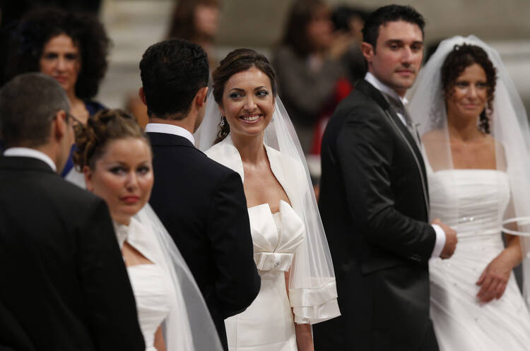 Newly married couples react after exchanging vows in St. Peter’s Basilica at the Vatican Sept. 14, 2014. Among those married were couples who already had children or have lived together before marriage. (CNS photo/Paul Haring)