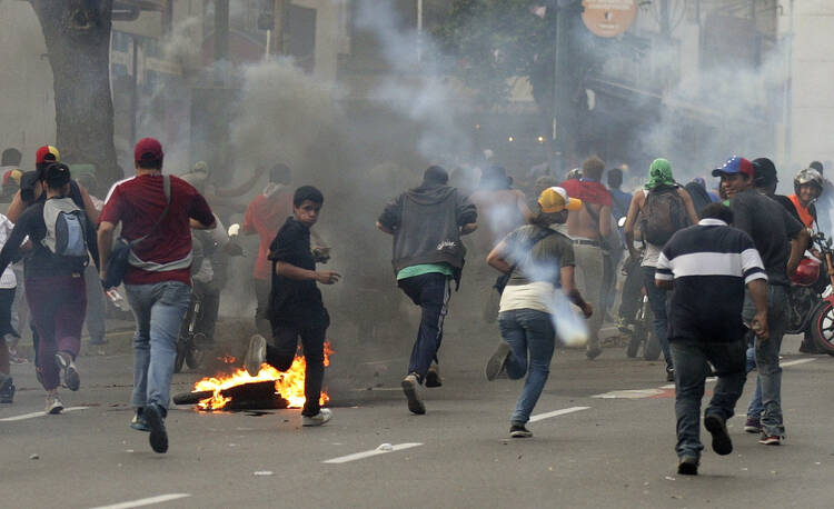 Supporters of opposition leader Henrique Capriles run from tear gas fired by riot police following voting in Caracas