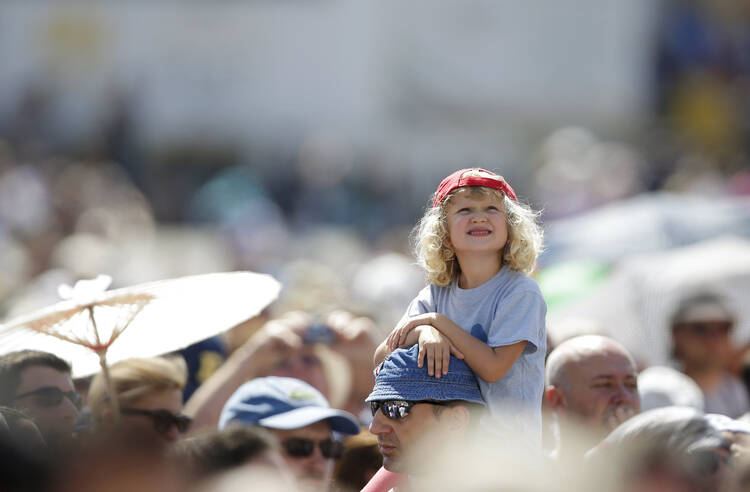 A child watches as Pope Francis leads the Angelus from the window of his studio overlooking St. Peter's Square at the Vatican Aug. 30. (CNS photo/Max Rossi, Reuters)