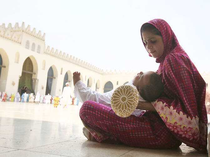 A Shiite woman calms her crying child as she waits with other Shiite Muslims from south Asia to greet their spiritual leader in Cairo, Egypt, on June 12, 2010. (Photo courtesy of Reuters/Asmaa Waguih)