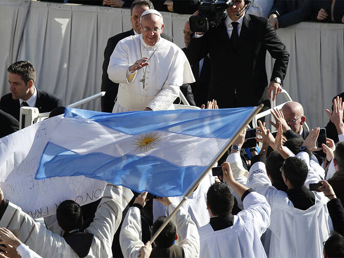 Pope Francis approaches priests with an Argentine flag as he arrives in St. Peter's Square for his inaugural Mass at the Vatican on March 19, 2013. (Photo courtesy of Reuters/Stefano Rellandini)