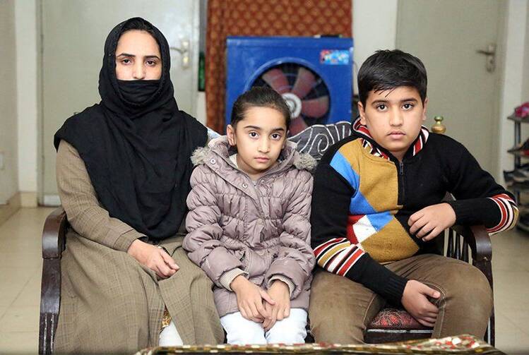 Ruby Tabbasum, left, the wife of an Ahmadi man who was killed in a hate crime in 2016, with her daughter, Huzaifa Ahmad, 9, and son, Amtul Mateen, 12, at their home in Rabwah, Pakistan. RNS photo by Naila Inayat