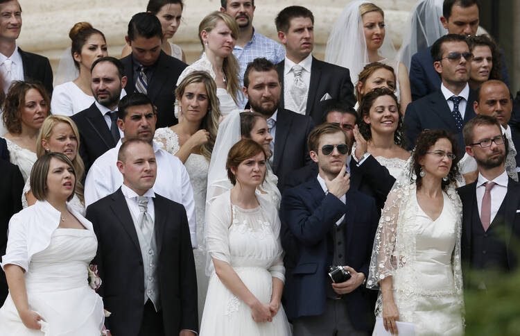 Newly married couples watch as Pope Francis leads his general audience in St. Peter's Square at the Vatican Sept. 10. (CNS photo/Paul Haring)