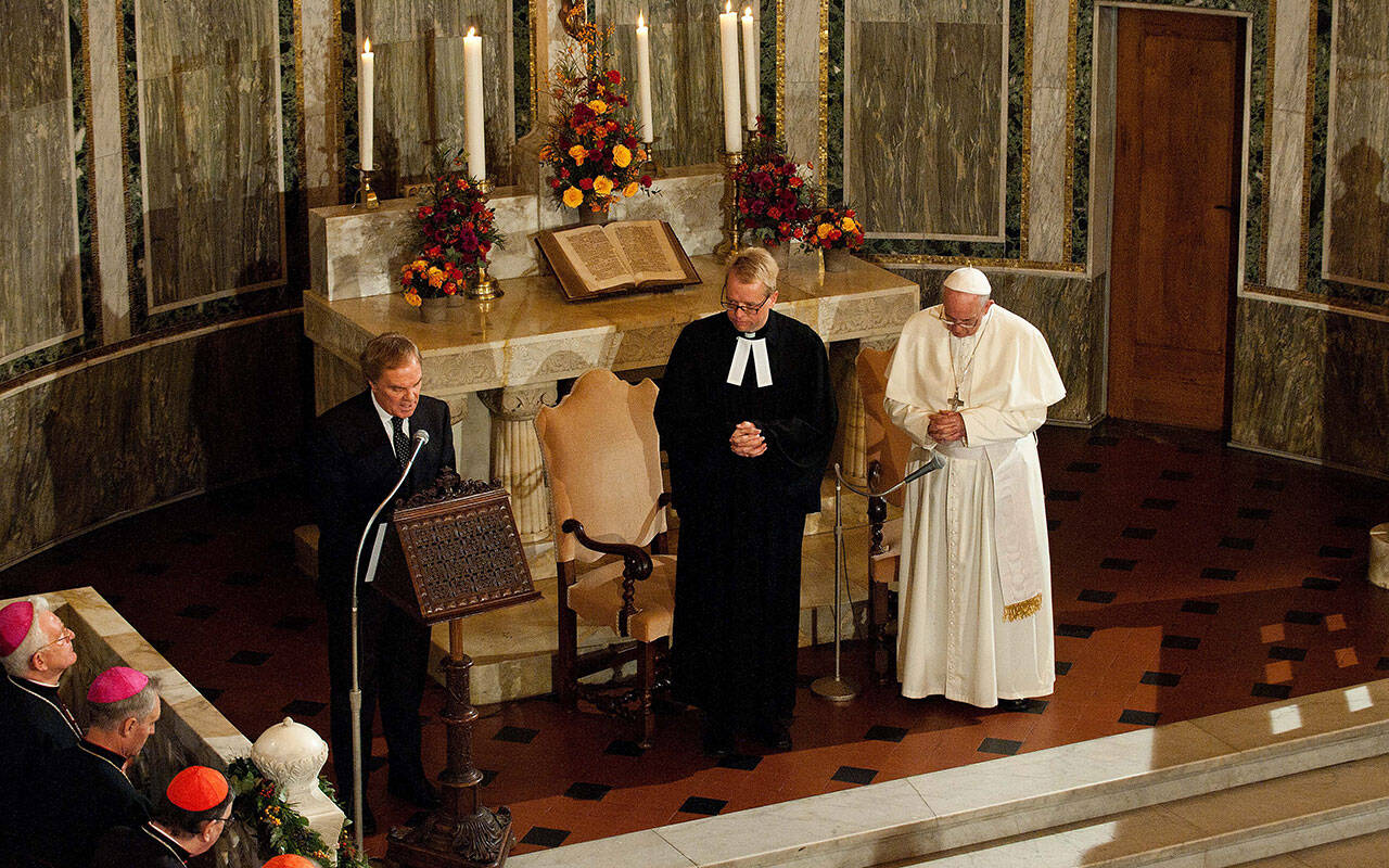 Pope Francis is flanked by Rev. Jens-Martin Kruse, during a visit to Christuskirche, a parish of the German Evangelical Lutheran Church, in Rome in this Nov. 15, 2015, file photo.