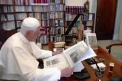Pope Benedict XVI reading the Vatican's L'Osservatore Romano newspaper (CNS photo/L'Osservatore Romano via Catholic Press Photos)