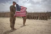 U.S. soldier hold American flag during Memorial Day ceremony in Afghanistan. (CNS photo/Danish Siddiqui, Reuters)