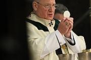 Cardinal Dolan of New York elevates Eucharist during Mass celebrated for St. Patrick's Day at St. Patrick's cathedral in New York (CNS photo/Gregory A. Shemitz).