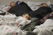 Detainees sleep in holding cell at U.S. Customs and Border Protection processing facility in Brownsville, Texas.