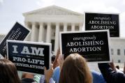 Pro-life supporters hold up signs as they celebrate U.S. Supreme Court ruling striking down buffer zones around abortion clinics. (CNS photo/Jim Bourg, Reuters)