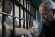 Priest prays with death-row inmate.