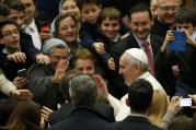 Pope Francis greets people as he leaves audience to give Christmas greetings to Vatican employees.