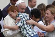 Pope Francis embraces Simone Zanini, 8, while greeting the disabled during his general audience in St. Peter's Square at the Vatican Sept. 2. (CNS photo/Paul Haring)