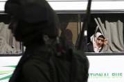 A Palestinian woman looks out a bus window during clashes between Palestinian protesters and Israeli troops in Hebron, West Bank, Oct. 4. (CNS photo/Mussa Qawasma, Reuters) 