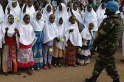 An U.N. peacekeeper stands guard as children wait for Pope Francis' arrival for a meeting with the Muslim community at the Koudoukou mosque in Bangui, Central African Republic, Nov. 30. (CNS photo/Paul Haring)