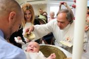 Deacon Mark Herrmann baptizes 4-month-old Victoria Marie Domke at St. Jude Church in Mastic Beach, N.Y., in 2013. (CNS photo/Gregory A. Shemitz)
