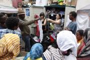Refugees receive clothing from volunteers on a street in Rome on July 14. Several refugees said they were planning to head north to countries such as France and Germany. (CNS photo/Paul Haring)