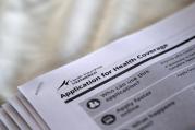 The federal government forms for applying for health coverage are seen at a 2013 rally held by supporters of the Affordable Care Act at a health care center in Jackson, Miss. (CNS photo/Jonathan Bachman, Reuters) 