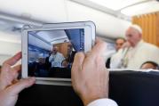 A journalist uses a tablet to photograph Pope Francis as he answers questions from journalists aboard his flight from Malmo, Sweden, to Rome Nov. 1. (CNS photo/Paul Haring) 