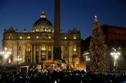 People take photos on their mobile devices as the Christmas tree is lit during a ceremony in St. Peter's Square at the Vatican on Dec. 9. (CNS photo/Paul Haring)