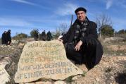 Bishop Oscar Cantu of Las Cruces, N.M., kneels by a stone that reads "We Refuse To Be Enemies" Jan. 16 at the entrance to the Tent of Nations in the West Bank, near Bethlehem. (CNS photo/Debbie Hill)