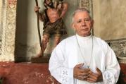 Bishop Ramon Castro Castro of Cuernavaca, Mexico, poses on March 26 in the Assumption of Mary Cathedral in front of an image of St. Christopher from the colonial period. (CNS photo/David Agren)