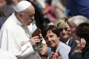 Pope Francis kisses a Marian statue presented by someone in the crowd during his general audience in St. Peter's Square at the Vatican on April 5. (CNS photo/Paul Haring)