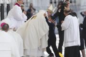 Pope Francis embraces Lucas Batista from Brazil as offertory gifts are presented during the canonization Mass of Sts. Francisco and Jacinta Marto.