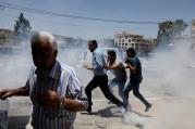Palestinian protesters run for cover from tear gas fired by Israeli troops in clashes on May 15 during a protest in the West Bank town of Bethlehem marking the 69th anniversary of their uprooting. Palestinians call the 1948 uprooting "nakba" or catastrophe. (CNS photo/Ammar Awad, Reuters)