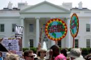 Protesters carry signs during the People's Climate March April 29 outside the White House in Washington. The U.S. bishops on June 1 urged President Donald Trump to honor the nation's commitment to the Paris climate pact and protect the planet. (CNS photo/Joshua Roberts) 